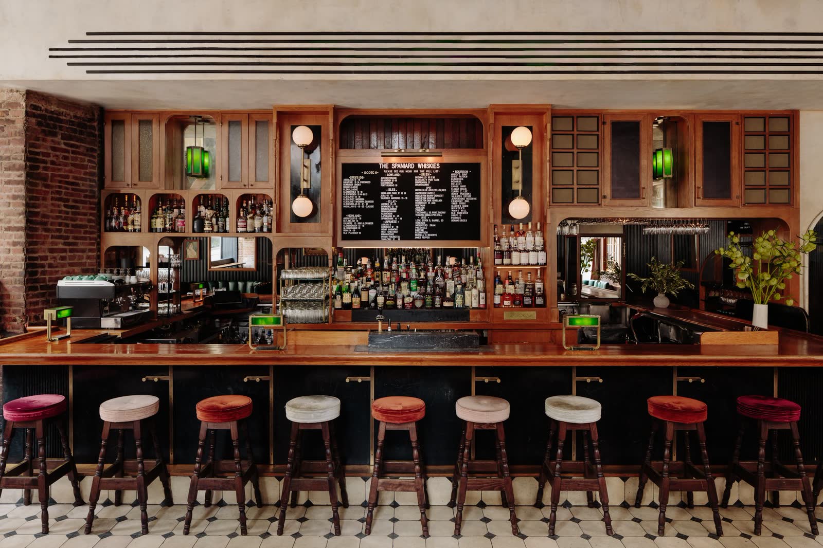 The Spaniard: the timber back bar, and an arched doorway beyond the booths